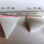 Detailed photo of König concept. Two TetraSnow foam flakes are photographed in such a way that the side edge of the base of the tetrahedron can be recognised with the aid of the metre rule behind it.